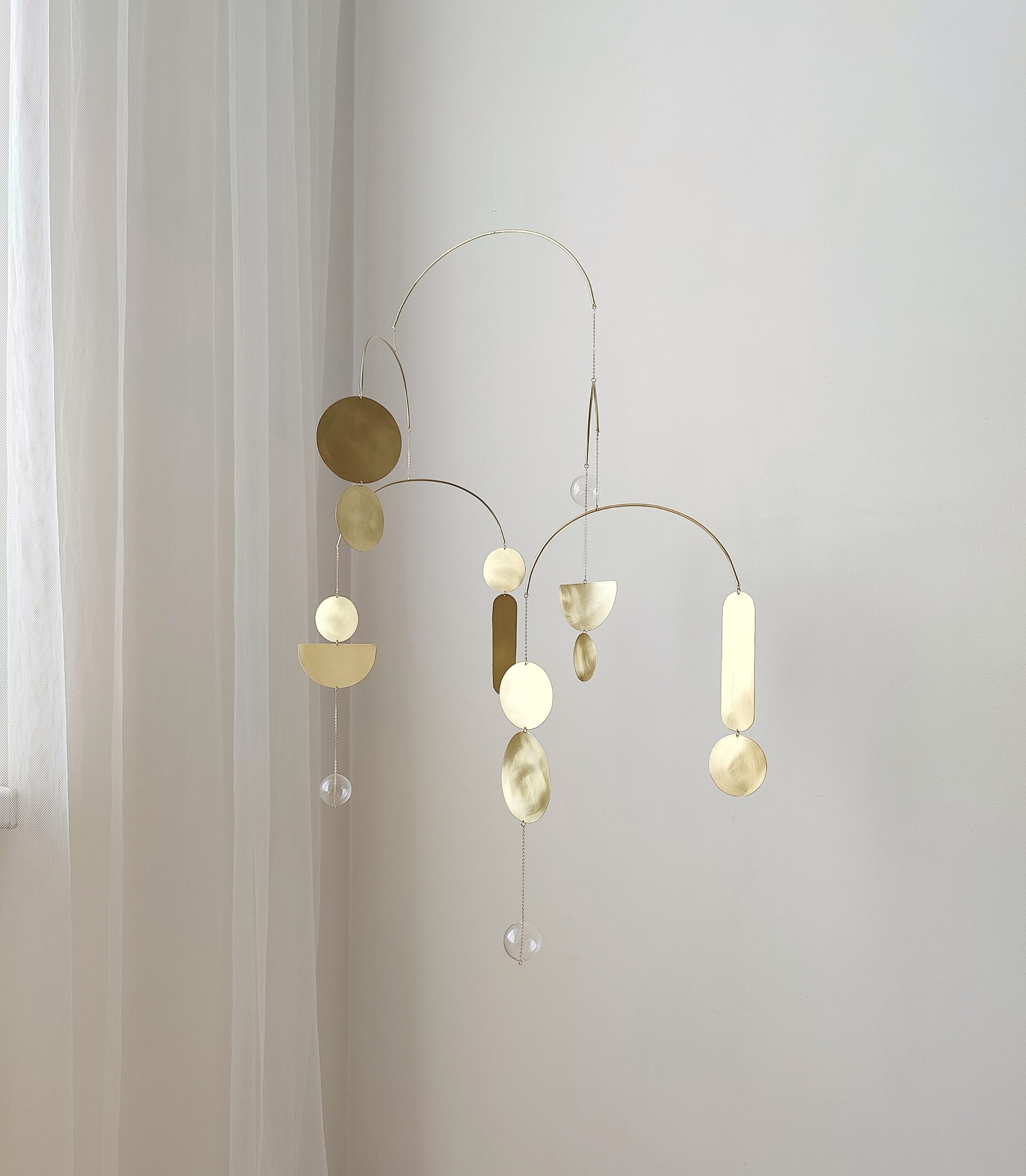 Modern brass wall hanging mobile with shimmering geometric elements – minimalist home decor accent